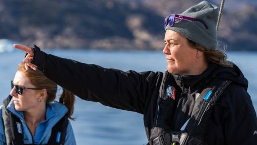 Female sailing skipper pointing at the scenery